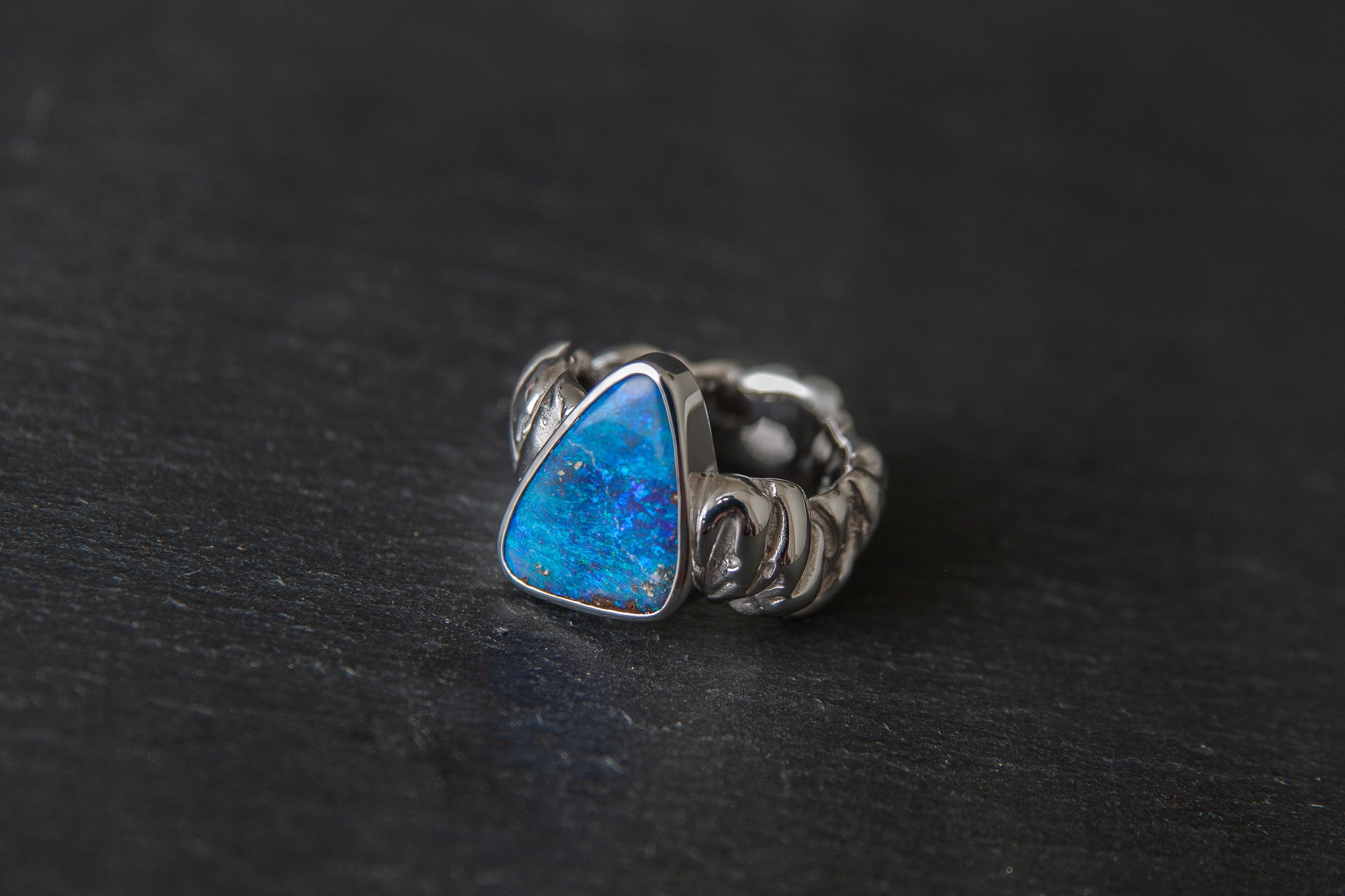 Ring aus Weissgold 750 mit strukturierter Schiene und einem farbintensiven Boulderopal als Mittelstein.