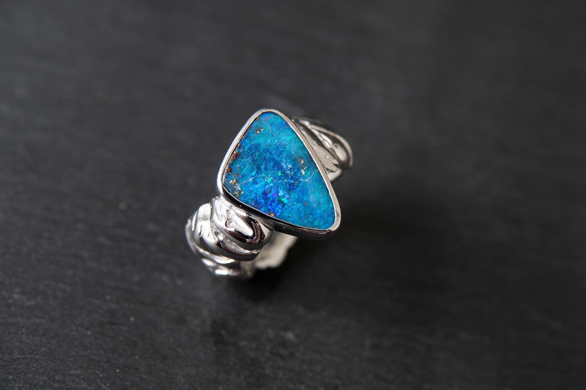 Ring aus Weissgold 750 mit strukturierter Schiene und einem farbintensiven Boulderopal als Mittelstein.