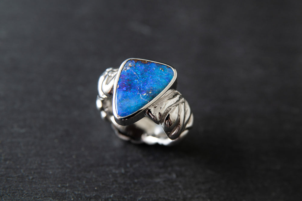 Ring aus Weissgold 750 mit strukturierter Schiene und einem farbintensiven Boulderopal als Mittelstein.