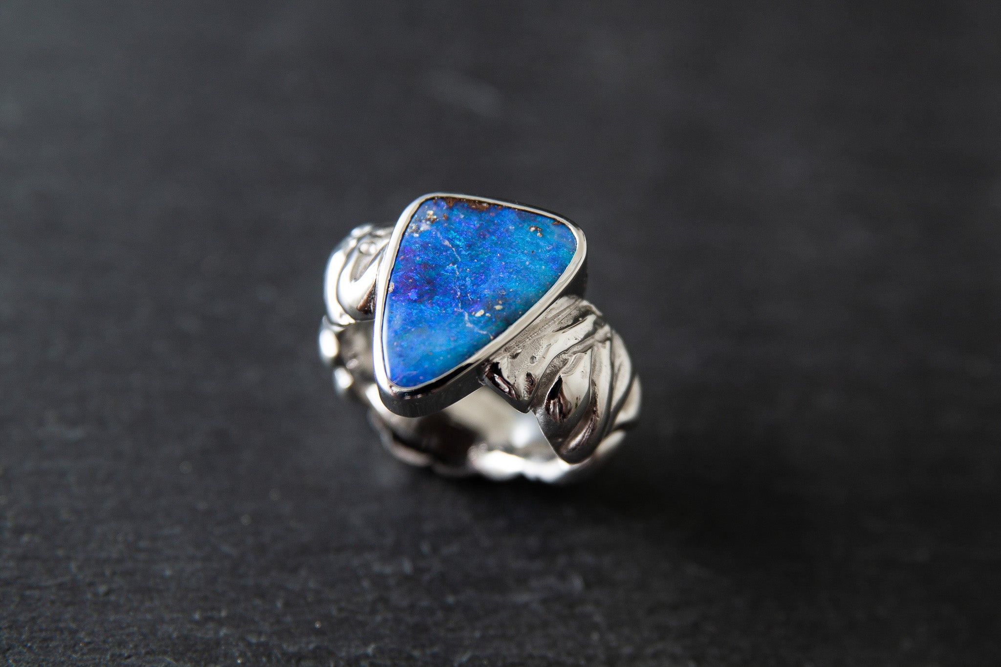 Ring aus Weissgold 750 mit strukturierter Schiene und einem farbintensiven Boulderopal als Mittelstein.