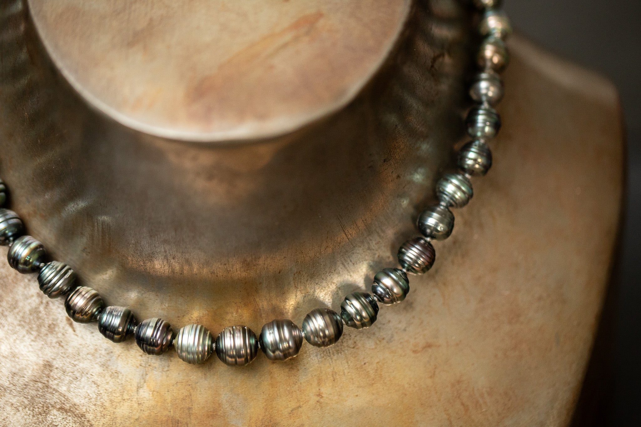 Dunkelgrün-graues Tahitiperlen-Collier mit gerillten Perlen und Wechselschließe aus Stahl.