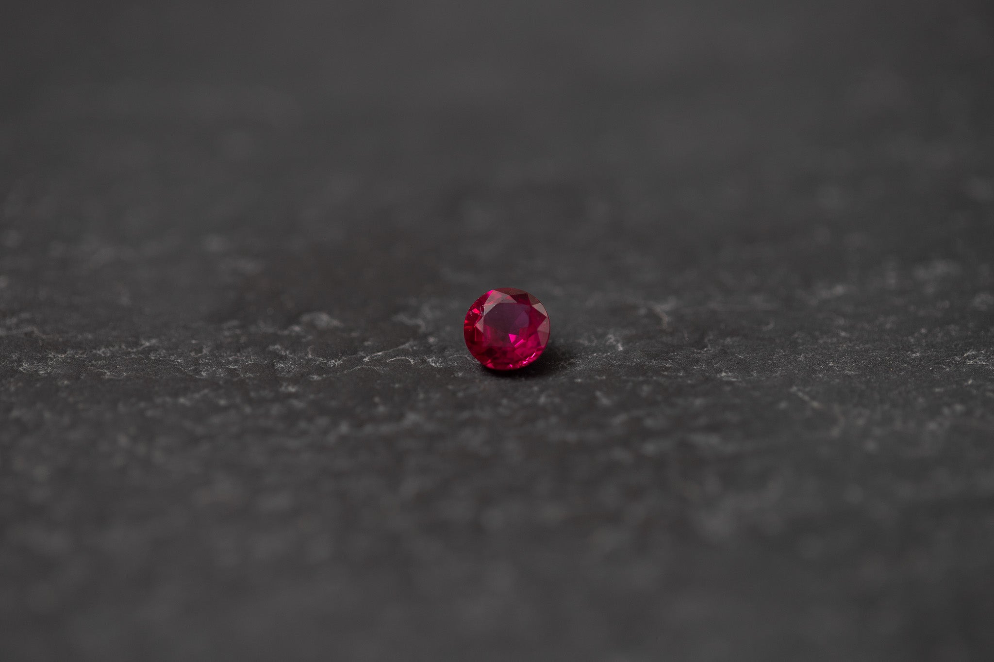 Runder, facettierter Rubin – hochwertiger Edelstein mit intensiver roter Farbe und brillanter Lichtreflexion