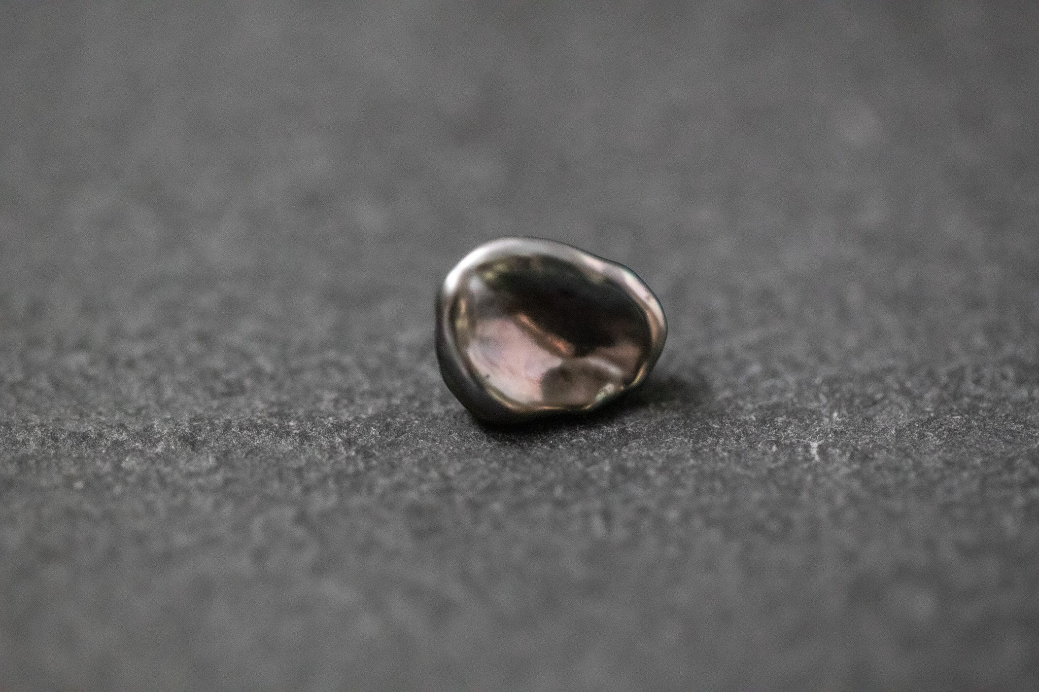 Dunkelgraue Tahitiperle in unregelmäßiger Keshi-Form mit starkem Glanz