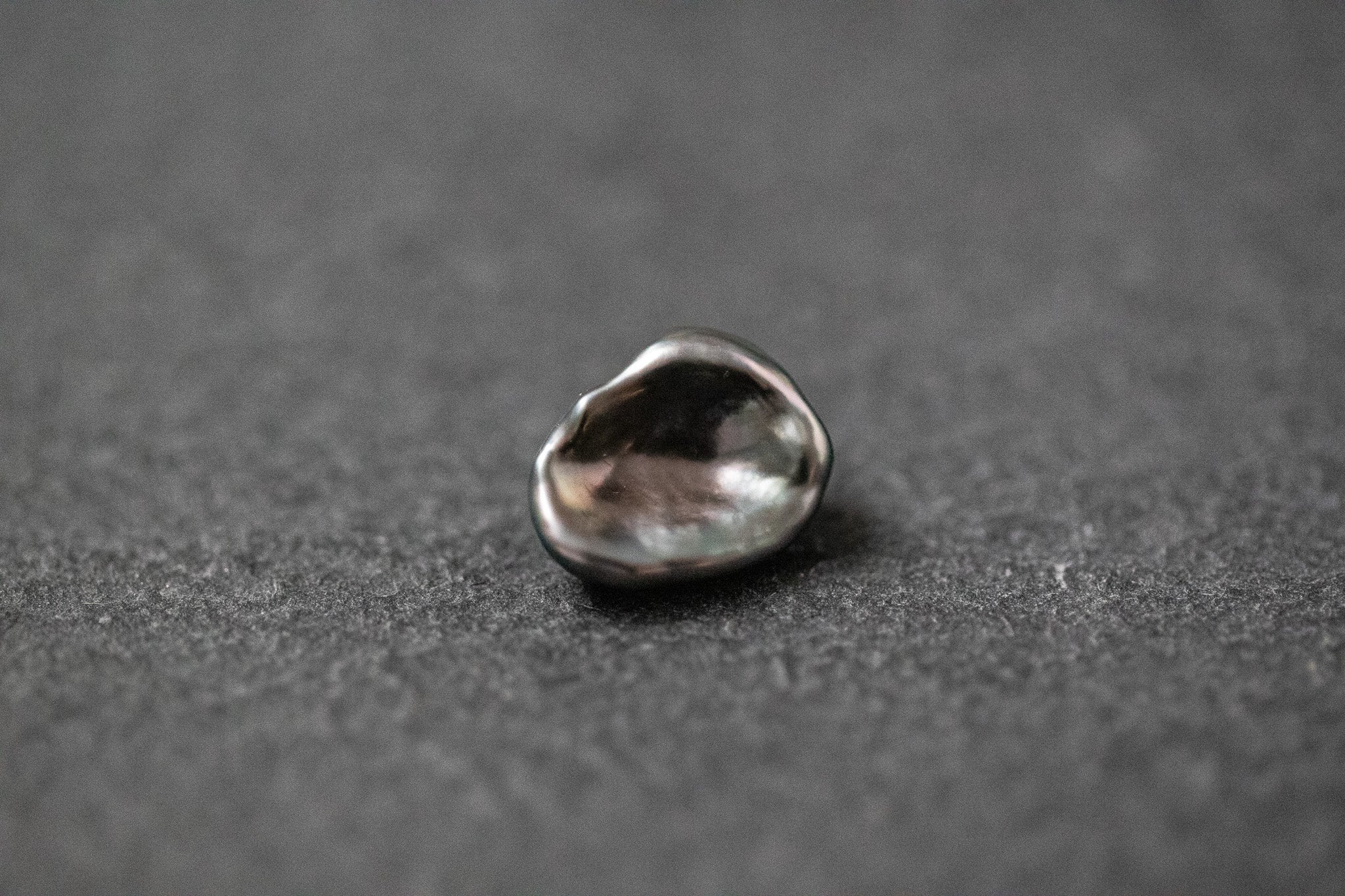 Dunkelgraue Tahitiperle in unregelmäßiger Keshi-Form mit starkem Glanz