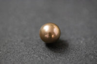 Runde Südseeperle in braun-goldenem Farbton mit starkem, metallischem Glanz