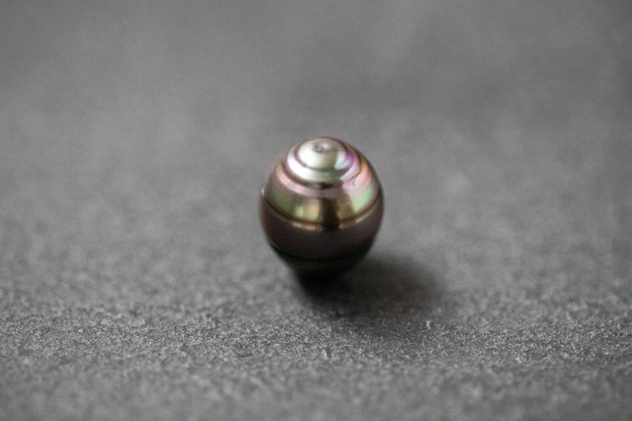 Ovale Tahitiperle mit gerillter Oberfläche und grauem Farbton 