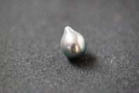 Einzelne Tahitiperle in hellgrauer Fantasieform mit feinem Lüster und organischer Oberfläche.