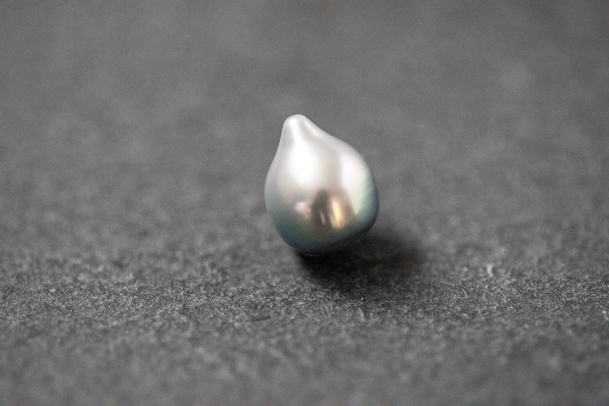 Einzelne Tahitiperle in hellgrauer Fantasieform mit feinem Lüster und organischer Oberfläche.