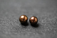 Zwei runde Frischwasserperlen in schokoladenbrauner Farbe mit weichem Glanz