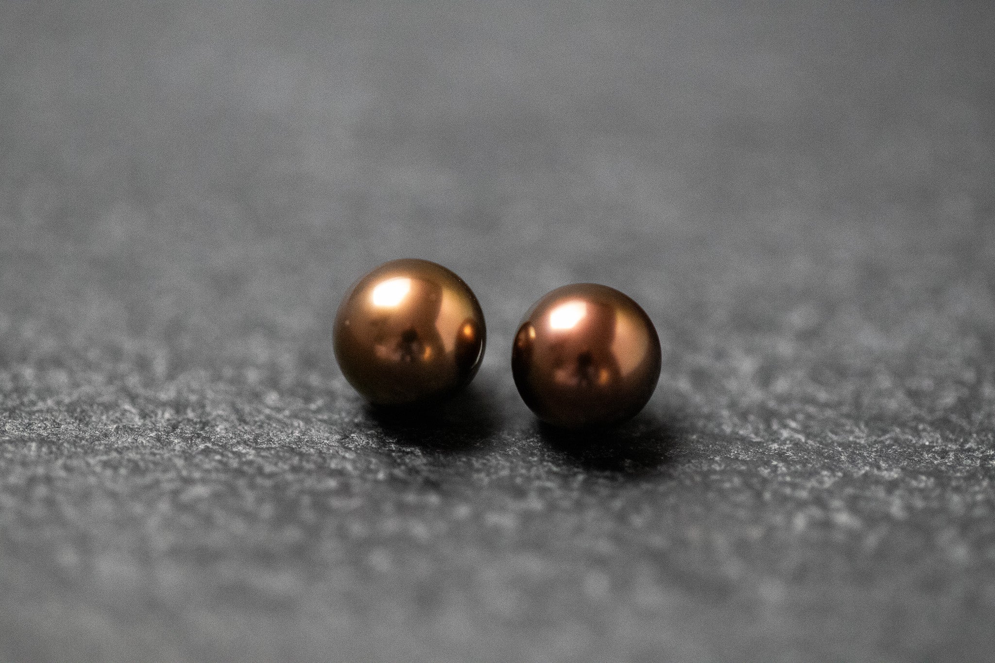 Zwei runde Frischwasserperlen in schokoladenbrauner Farbe mit weichem Glanz
