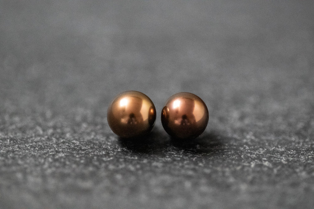 Zwei runde Frischwasserperlen in schokoladenbrauner Farbe mit weichem Glanz
