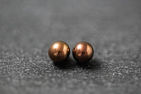 Zwei runde Frischwasserperlen in schokoladenbrauner Farbe mit weichem Glanz