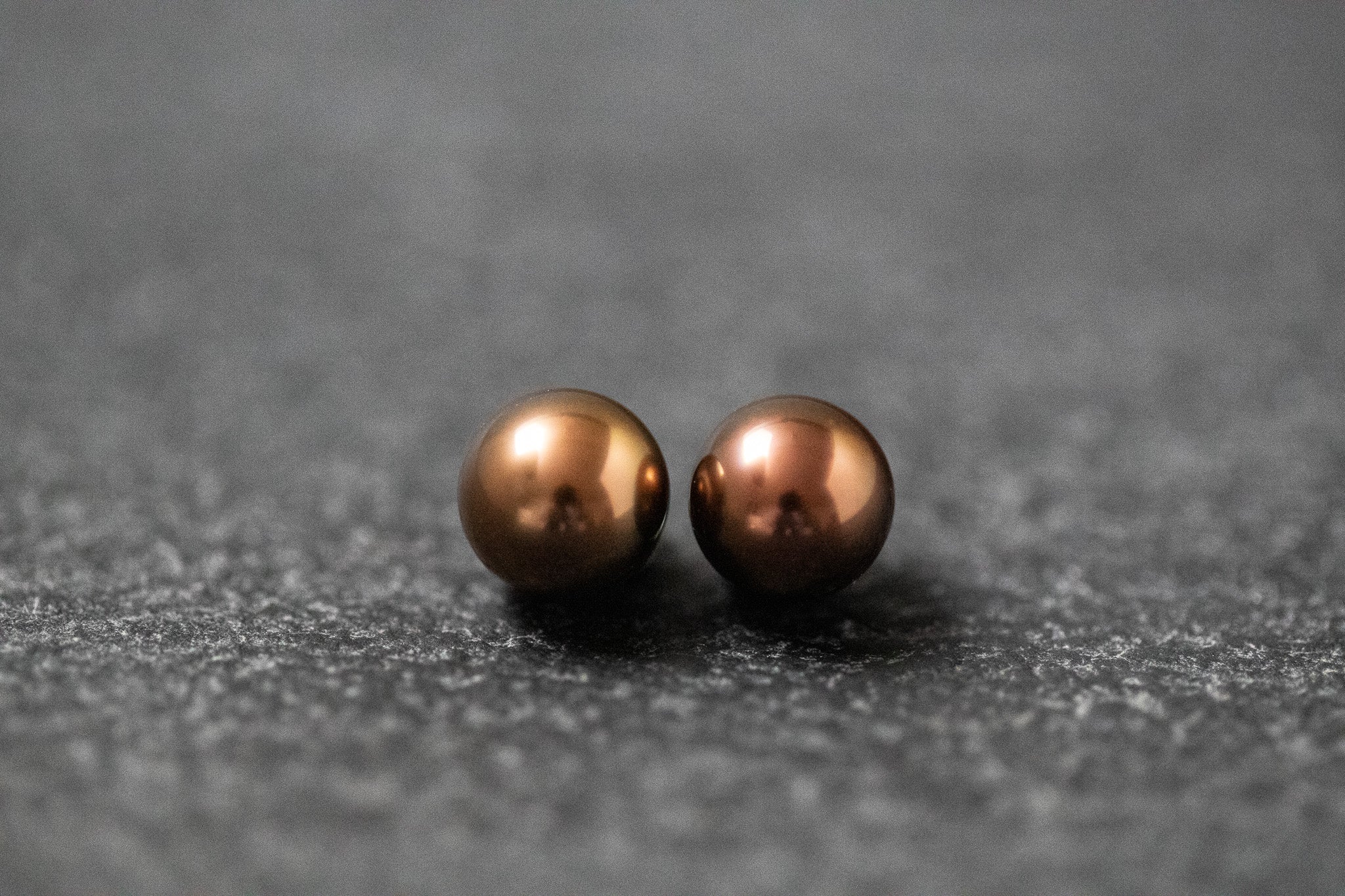 Zwei runde Frischwasserperlen in schokoladenbrauner Farbe mit weichem Glanz