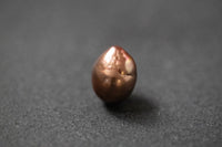 Oval geformte Frischwasserperle in warmem Schokoladenbraun mit glänzender Oberfläche