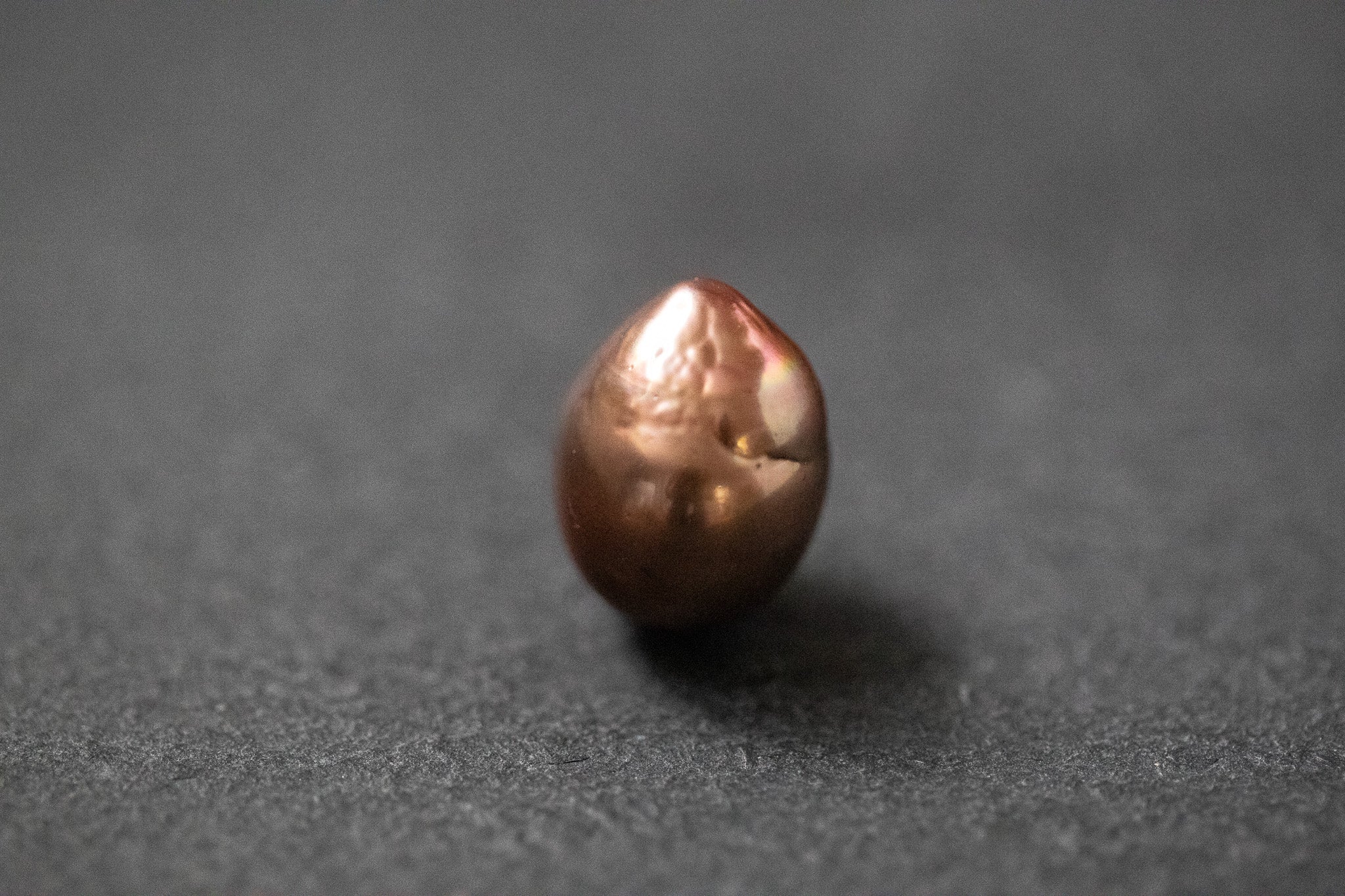 Oval geformte Frischwasserperle in warmem Schokoladenbraun mit glänzender Oberfläche