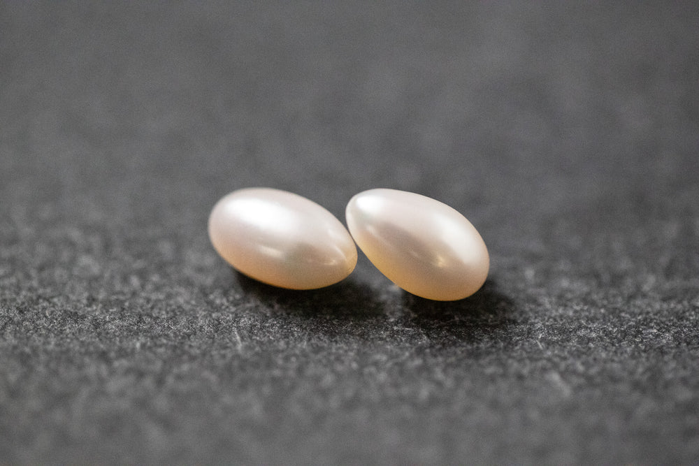 Paar ovaler, weißer Frischwasserperlen mit glatter Oberfläche und natürlichem Glanz – ideal für Schmuckherstellung