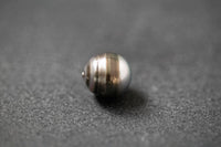 Oval geformte Tahitiperle mit fließendem Grau-Verlauf und seidig schimmernder Oberfläche