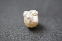 Barocke Frischwasserperle mit unregelmäßiger Form und schimmerndem Farbverlauf in Gelb und Weiss