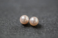 Zwei runde, weiße Akoya-Perlen mit starkem Lüster