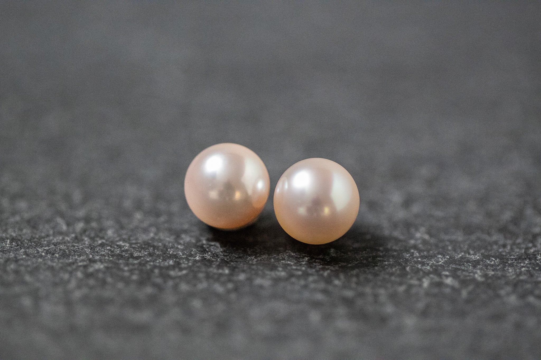 Zwei runde, weiße Akoya-Perlen mit starkem Lüster