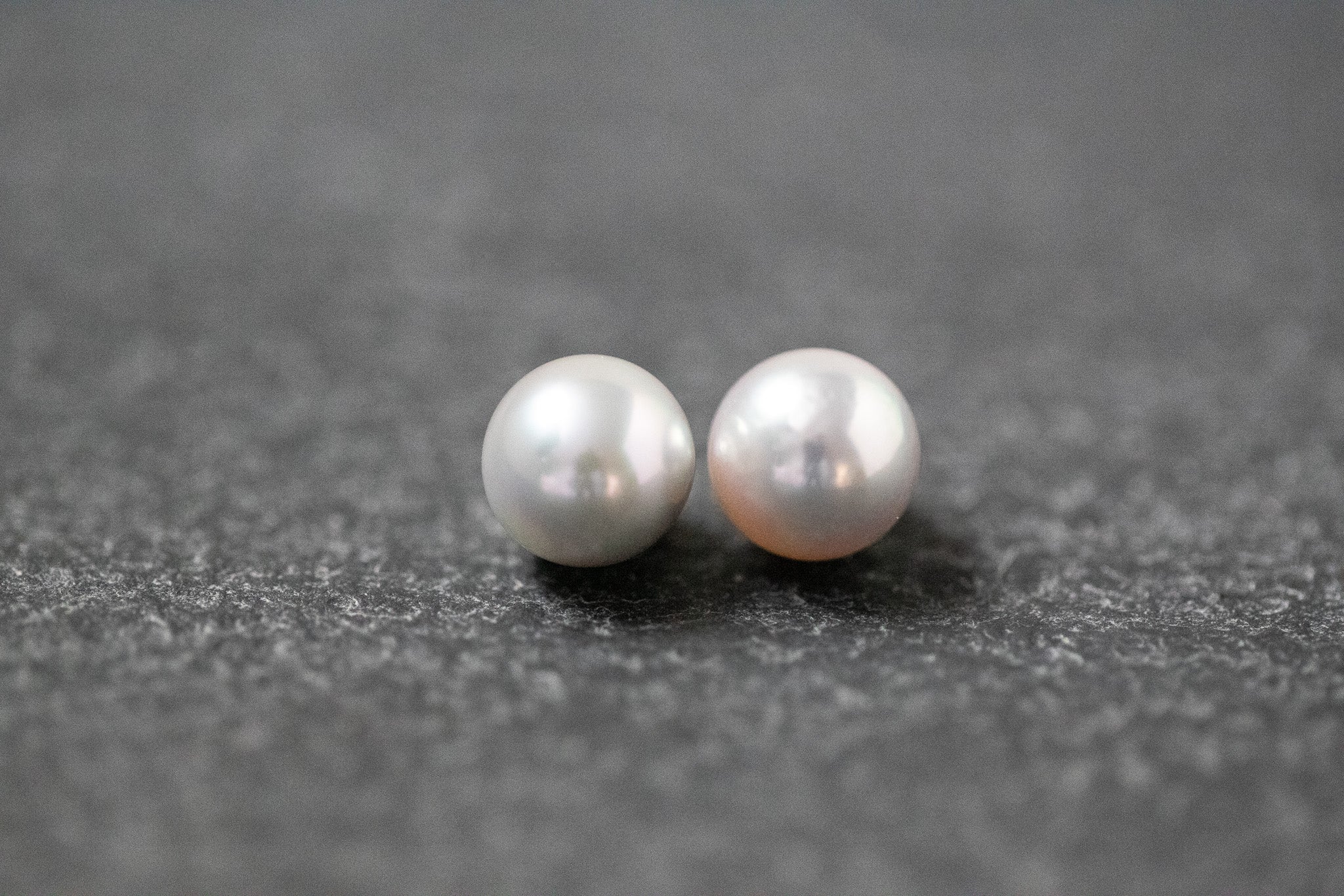 Zwei runde, graue Akoya-Perlen mit glänzender Oberfläche