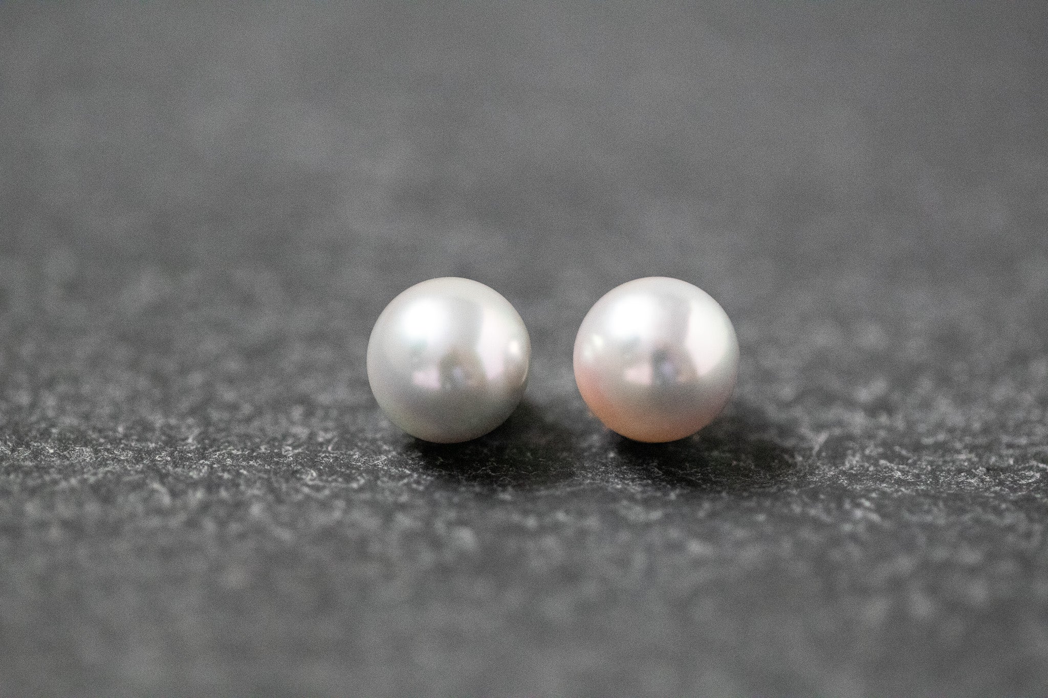Zwei runde, graue Akoya-Perlen mit glänzender Oberfläche