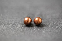 Zwei runde Frischwasserperlen in schokobrauner Farbe mit sanftem Glanz