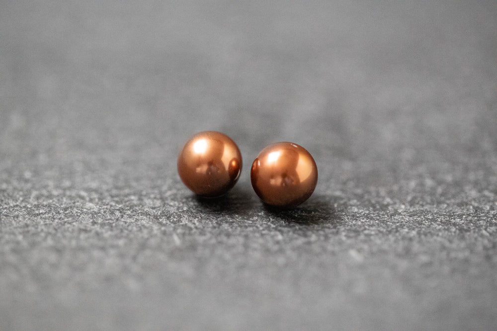 Zwei runde Frischwasserperlen in schokobrauner Farbe mit sanftem Glanz