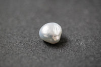 Frischwasserperle in hellgrauer Fantasieform mit natürlicher Struktur und sanftem Glanz.