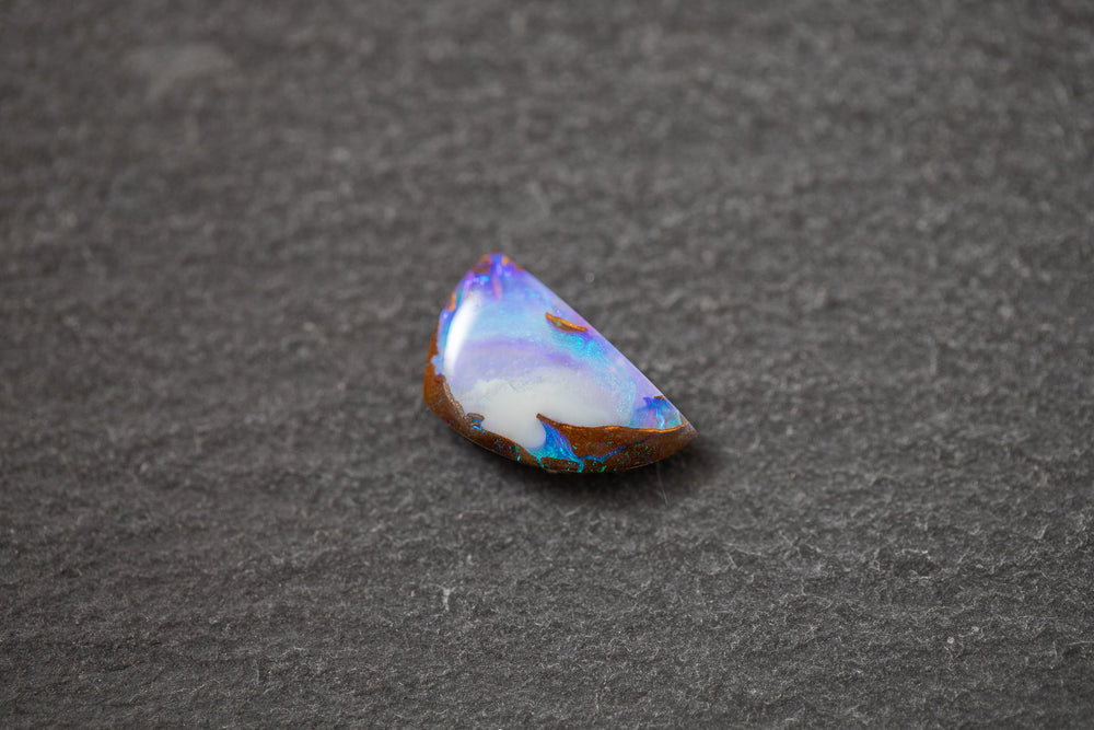 Boulderopal in Fantasieform mit intensivem Farbspiel in Violett, Weiß und Blau – natürlicher Edelstein mit einzigartiger Struktur