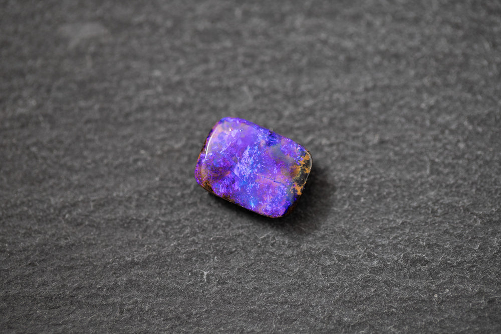 Boulderopal in Fantasieform mit intensivem Farbspiel in Violett und Blau – natürlicher Edelstein mit einzigartiger Struktur