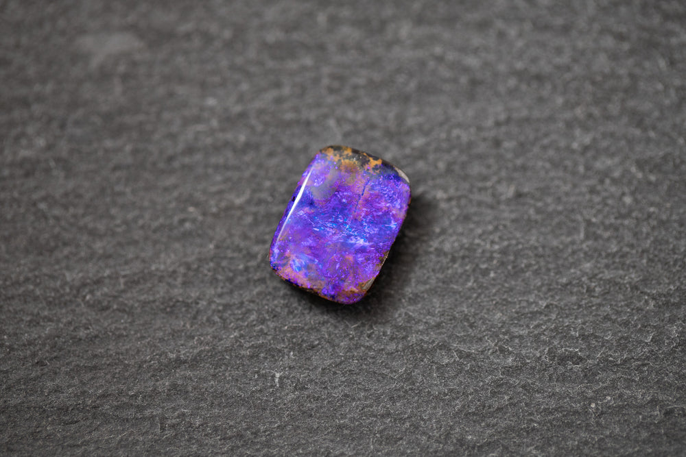 Boulderopal in Fantasieform mit intensivem Farbspiel in Violett und Blau – natürlicher Edelstein mit einzigartiger Struktur