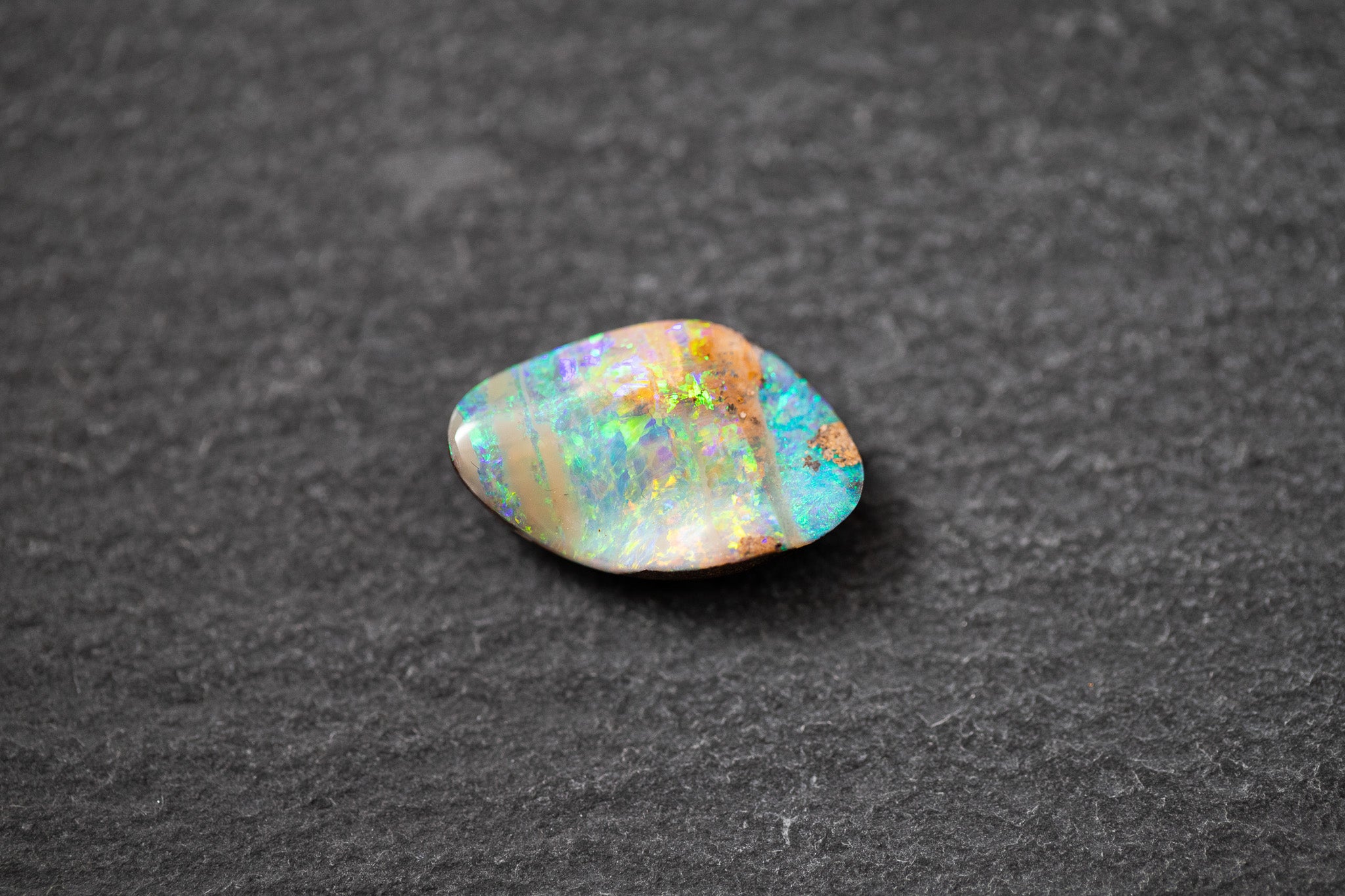 Boulderopal in Fantasieform mit intensivem Farbspiel in Blau, Grün und Violett – natürlicher Edelstein mit einzigartiger Struktur