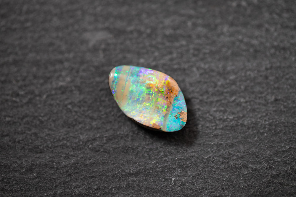 Boulderopal in Fantasieform mit intensivem Farbspiel in Blau, Grün und Violett – natürlicher Edelstein mit einzigartiger Struktur