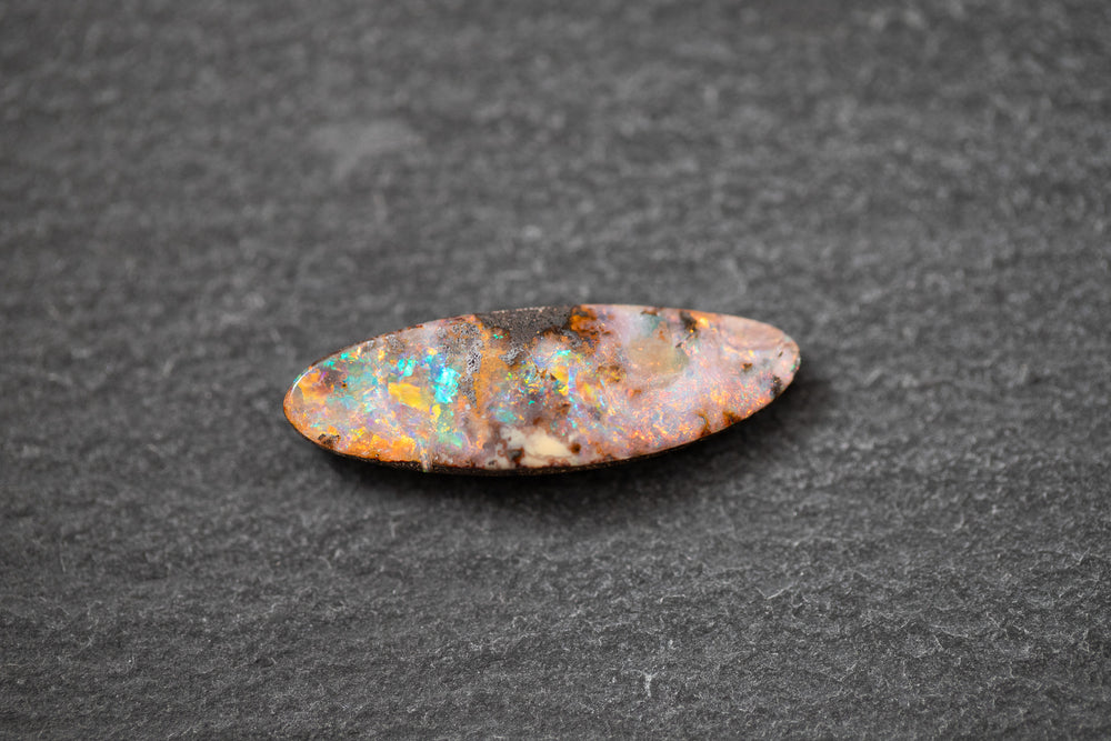 Boulderopal in Fantasieform mit intensivem Farbspiel in Rot, Blau und Grün – natürlicher Edelstein mit einzigartiger Struktur