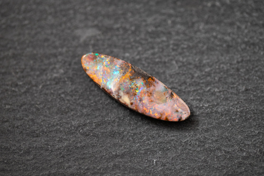 Boulderopal in Fantasieform mit intensivem Farbspiel in Rot, Blau und Grün – natürlicher Edelstein mit einzigartiger Struktur